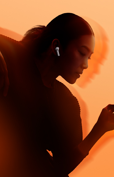 En person med AirPods 5 i ørerne og armene bøjet mod en baggrund i flere farver
