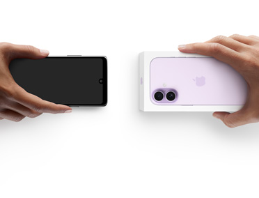 スマートフォンを交換する2つの手。左側に箱のないAndroidスマートフォンがあり、右側に箱に入った新しいiPhone 17がある